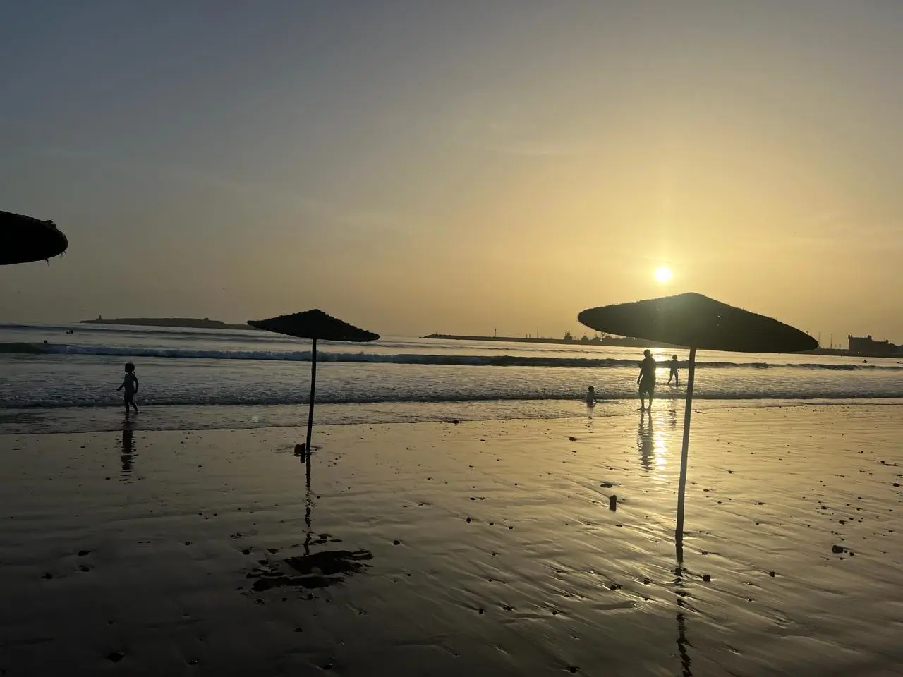 Golden Sunset Over Essaouira Beach with Thatched Umbrellas