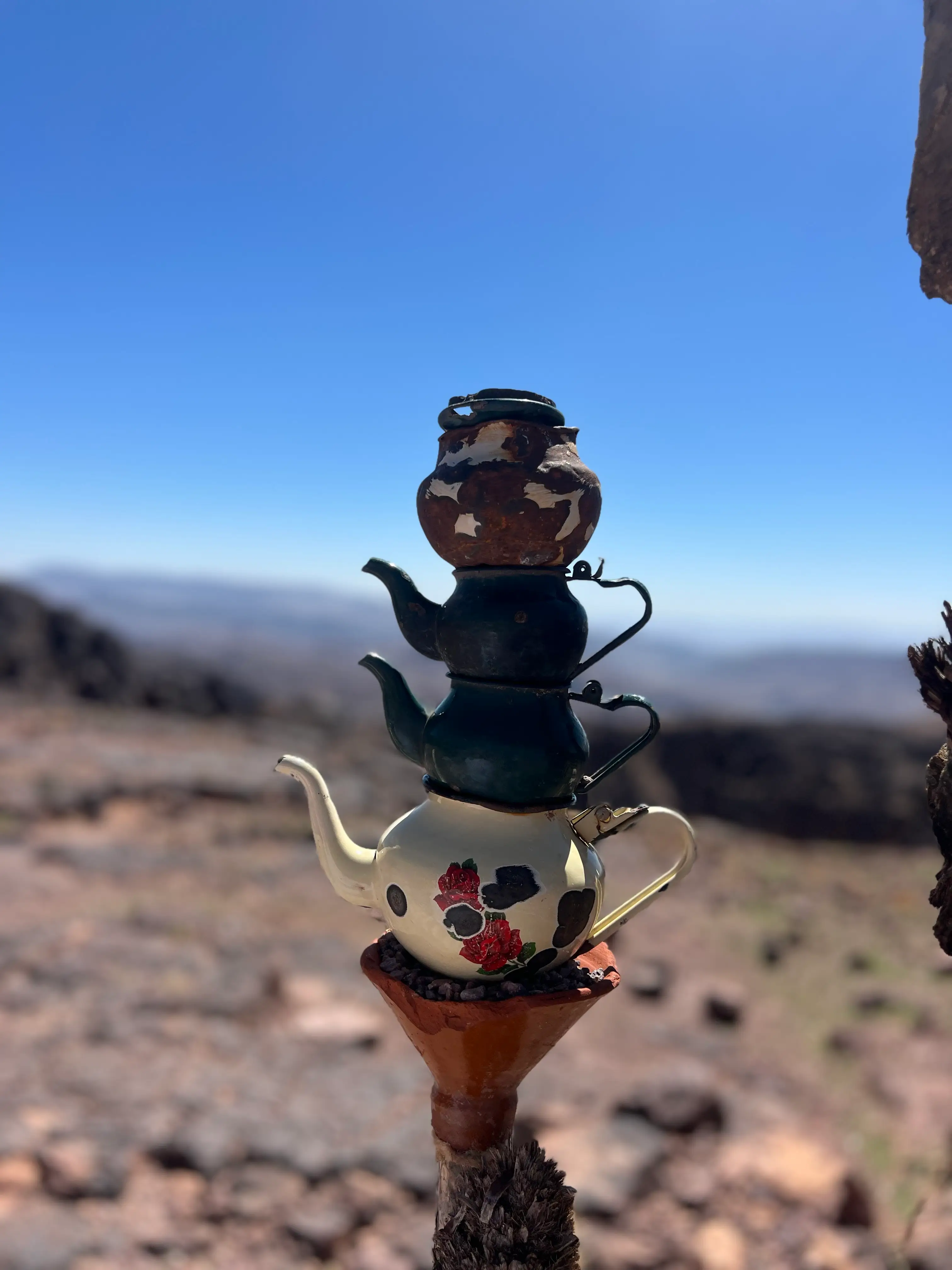 Stacked Traditional Moroccan Teapots on Desert Mountain Peak